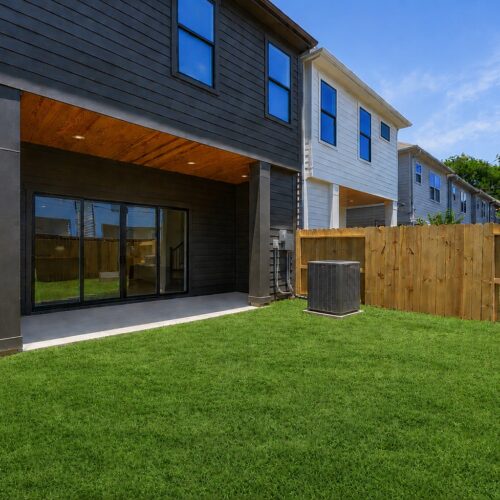 Private backyard in luxury home in The Heights Houston featuring a covered patio, fenced green space, and indoor-outdoor living.