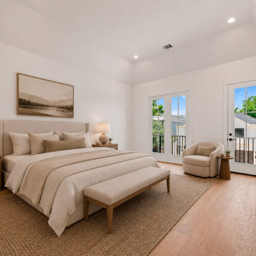Luxury primary suite in The Heights Houston featuring vaulted ceilings, private balcony access, hardwood floors, and abundant natural light.